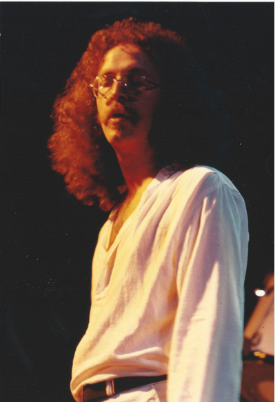 Young Robert L. Hunt performing live on stage during a vintage southern rock music concert.